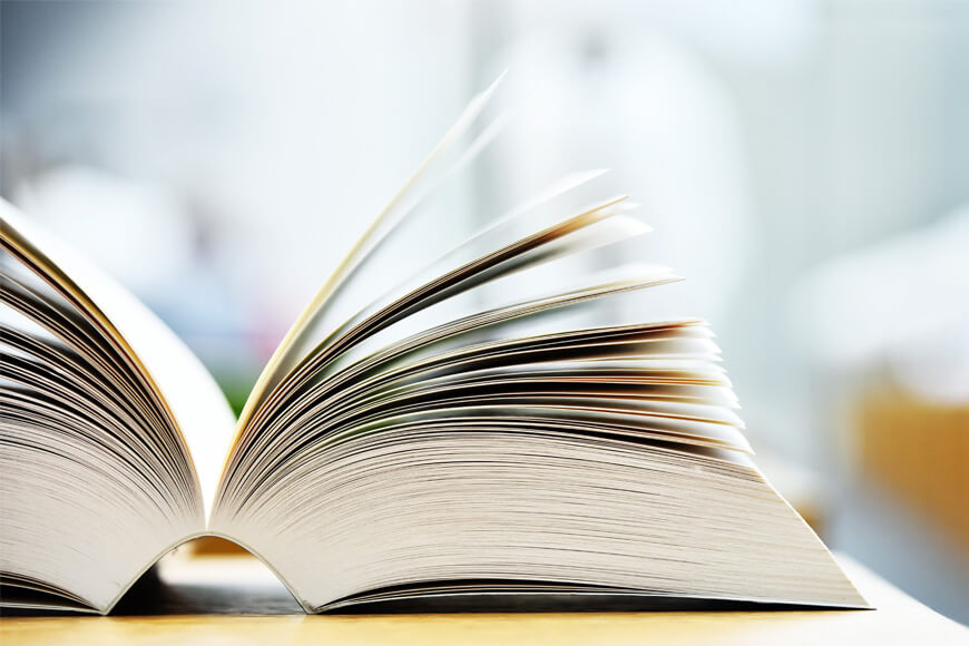 Aufgeschlagenes Buch auf dem Tisch einer öffentlichen Bibliothek